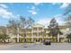 Bright yellow condo building with white balconies and well-maintained landscaping creating a welcoming curb appeal at 313 Lucaya Loop # 313, Davenport, FL 33897