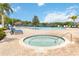 Community pool and hot tub area with blue lounge chairs, umbrellas, and a view of the trees at 313 Lucaya Loop # 313, Davenport, FL 33897