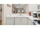 Condo kitchen with white cabinets, white countertops, and stainless steel appliances looking into the living room at 313 Lucaya Loop # 313, Davenport, FL 33897