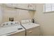 Practical laundry area equipped with a washer, dryer, and shelving at 313 Lucaya Loop # 313, Davenport, FL 33897