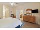 Comfortable main bedroom with a wood dresser, a TV, an en-suite bathroom, and an open doorway to the dining area at 313 Lucaya Loop # 313, Davenport, FL 33897