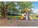 Brightly colored playground with a slide, climbing wall, swings, and benches in the shade at 313 Lucaya Loop # 313, Davenport, FL 33897