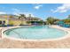 Large community pool and lounge area with umbrellas and a view of the yellow clubhouse at 313 Lucaya Loop # 313, Davenport, FL 33897