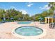 Community pool and hot tub surrounded by lounge chairs and lush tropical landscaping at 313 Lucaya Loop # 313, Davenport, FL 33897