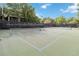 Tennis court with a black fence surrounding it and lush green trees behind it in the distance at 313 Lucaya Loop # 313, Davenport, FL 33897