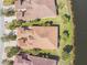 Birds-eye view of rooftops, manicured lawns, mature trees, and a tranquil lake, showcasing the property's setting at 3390 Fallbrook Dr, Kissimmee, FL 34759