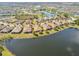 Expansive aerial view of a residential community bordering a lake, highlighting the neighborhood's peaceful setting at 3390 Fallbrook Dr, Kissimmee, FL 34759
