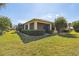 Backyard featuring a screened lanai, beautiful shrubbery, and a well-maintained lawn at 3390 Fallbrook Dr, Kissimmee, FL 34759