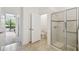 Bright bathroom with a tiled floor, glass shower, and an open doorway to another room at 3390 Fallbrook Dr, Kissimmee, FL 34759