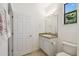 Bathroom featuring a granite countertop vanity, a mirror, and a window for natural light at 3390 Fallbrook Dr, Kissimmee, FL 34759