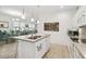 Open-concept kitchen with white cabinets, modern appliances, and adjacent dining area at 3390 Fallbrook Dr, Kissimmee, FL 34759