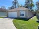 Charming one-story home with a one car garage and well-maintained lawn on a sunny day at 401 Talquin Ct, Orlando, FL 32807