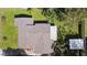Aerial view of a home highlighting the roof, yard, and surrounding greenery at 401 Woodlawn Ter, Kissimmee, FL 34744