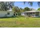 The backyard features a manicured lawn, beautiful shade trees and a bird feeder at 401 Woodlawn Ter, Kissimmee, FL 34744