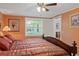 View of bedroom with decorative ceiling fan, orange walls, and a view of the backyard at 401 Woodlawn Ter, Kissimmee, FL 34744