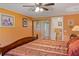 Bedroom showcasing a decorative ceiling fan, closet with sliding mirror doors, and orange colored walls at 401 Woodlawn Ter, Kissimmee, FL 34744