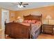 Comfortable bedroom features a wood bed frame, ceiling fan, and attached bathroom with shower at 401 Woodlawn Ter, Kissimmee, FL 34744