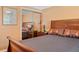 This bedroom features a wood bed frame, orange colored walls, and a closet with sliding mirror doors at 401 Woodlawn Ter, Kissimmee, FL 34744