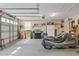 A spacious two-car garage, complete with shelving, a refrigerator, and garage doors on two sides at 401 Woodlawn Ter, Kissimmee, FL 34744