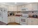 Well-equipped kitchen features white appliances, countertops, and cabinetry, offering a functional and classic culinary space at 401 Woodlawn Ter, Kissimmee, FL 34744