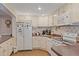 Charming kitchen featuring white cabinetry, tile backsplash, and modern appliances, creating a cozy and functional space at 401 Woodlawn Ter, Kissimmee, FL 34744