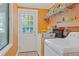 This laundry room includes a washer, dryer, storage shelves, and a window with a view to the outdoors at 401 Woodlawn Ter, Kissimmee, FL 34744