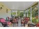 This is a screened-in patio that includes tiled floors, comfortable wicker chairs and views of the backyard at 401 Woodlawn Ter, Kissimmee, FL 34744