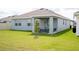 The home's backyard features healthy grass, outdoor seating, and a sliding glass door entrance at 4211 Little Owl Ln, Kissimmee, FL 34746