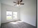 Bright bedroom with carpet flooring, two windows, and a ceiling fan at 4211 Little Owl Ln, Kissimmee, FL 34746