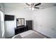 A nicely appointed bedroom with TV, ceiling fan, and dark wood furniture including dresser with mirror at 4211 Little Owl Ln, Kissimmee, FL 34746