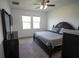 Bedroom featuring a large bed, dark furniture, two windows, and a ceiling fan at 4211 Little Owl Ln, Kissimmee, FL 34746
