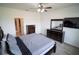 This bedroom features a dresser, a ceiling fan, and a mounted television at 4211 Little Owl Ln, Kissimmee, FL 34746