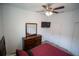 Comfortable bedroom with dresser and TV mounted to the wall and ceiling fan at 4211 Little Owl Ln, Kissimmee, FL 34746
