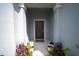 Inviting entryway with potted plants leading to the dark-colored front door and welcome mat at 4211 Little Owl Ln, Kissimmee, FL 34746