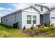 Side exterior view of the home featuring a well-maintained lawn and meticulously arranged flowerbeds at 4211 Little Owl Ln, Kissimmee, FL 34746