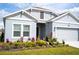 Front exterior view of the home showcasing its well-manicured lawn and beautifully arranged flowerbeds at 4211 Little Owl Ln, Kissimmee, FL 34746