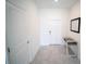 Hallway featuring a glass-topped table, a mirror, and neutral colored tile flooring at 4211 Little Owl Ln, Kissimmee, FL 34746
