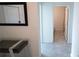Hallway featuring neutral colored tile flooring leading to a view of the bathroom at 4211 Little Owl Ln, Kissimmee, FL 34746