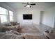Cozy living room featuring neutral sofas, a ceiling fan, and a large screen television at 4211 Little Owl Ln, Kissimmee, FL 34746