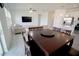 Open floor plan with a large dining table and a view of the living room and modern kitchen at 4211 Little Owl Ln, Kissimmee, FL 34746