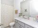 This bathroom features a white vanity, large mirror, and shower with patterned curtain at 4507 Lions Gate Ave, Clermont, FL 34711