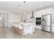 Modern kitchen boasts a large center island with seating, stainless steel appliances, and white cabinetry at 4507 Lions Gate Ave, Clermont, FL 34711