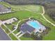 Overhead view of the community pool with lounge seating, verdant greenery, and nearby park at 4507 Lions Gate Ave, Clermont, FL 34711