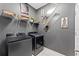 A modern laundry room featuring front loading washer and dryer set, shelving with storage, and minimalist decor at 485 Disa Dr, Davenport, FL 33837