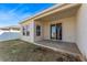 A cozy covered patio with sliding glass doors and a view of the partially seeded backyard at 485 Disa Dr, Davenport, FL 33837
