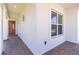 Covered entryway featuring brick pavers, leading to the home's front door and adjacent window at 4918 Drawdy Ct, St Cloud, FL 34772