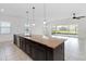 Kitchen island with stainless steel dishwasher and sink, granite countertop, and dark cabinets at 4918 Drawdy Ct, St Cloud, FL 34772