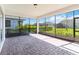 A covered and screened-in brick patio with views of the fenced backyard at 4918 Drawdy Ct, St Cloud, FL 34772