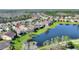 Picturesque aerial view of homes backing up to a tranquil pond, surrounded by lush greenery and natural beauty at 555 Presido Park Pl, Kissimmee, FL 34759