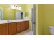 This is a yellow full bathroom with double sinks, updated fixtures, and tile floors at 555 Presido Park Pl, Kissimmee, FL 34759